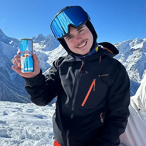 Photographie montrant Thibault Gillet a l'extérieur en montagne montrant une canette de redbull