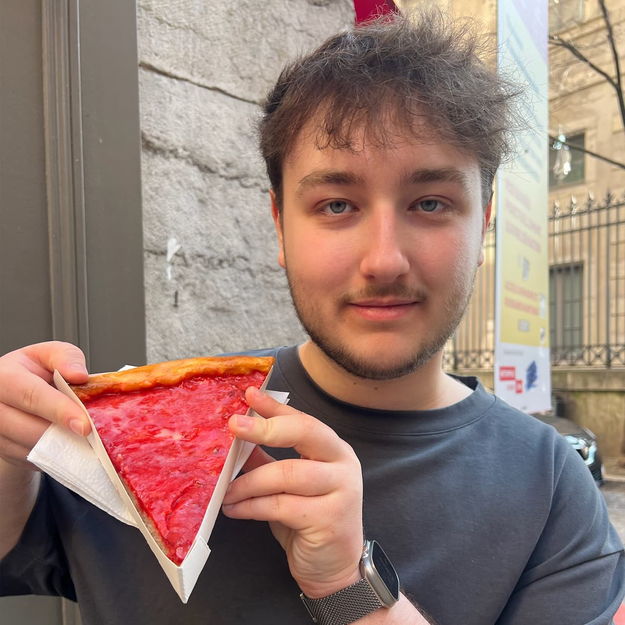 Photo portrait de Keelan souriant présentant à l'objectif une part de tarte aux pralines.